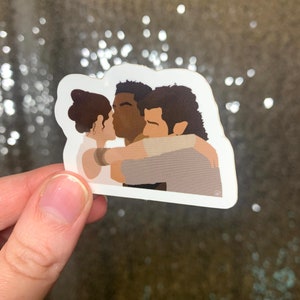 May include: A sticker depicting three figures in an embrace, with one kissing the other. The illustration uses muted colours and simple lines. The sticker is held up against a shimmering, glittery backdrop.