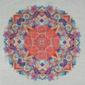 May include: A detailed, circular cross-stitch design featuring a vibrant array of colors. The central focus is a coral-colored floral pattern, surrounded by intricate geometric shapes and swirling patterns in shades of blue, purple, and peach. The background is a neutral, light beige fabric.