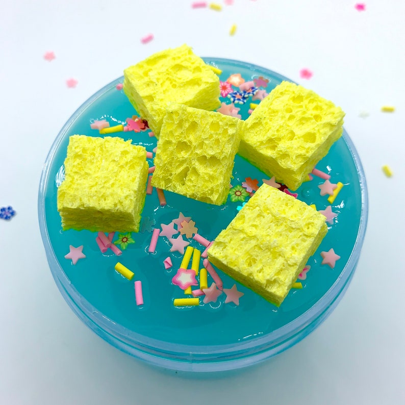 May include: Yellow sponge squares in a blue slime with pink and yellow sprinkles.
