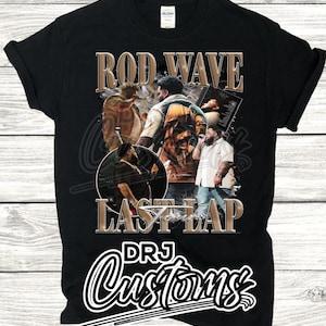 May include: Black t-shirt with a graphic of Rod Wave, a rapper, with the text "Rod Wave" and "Last Lap" in gold lettering. The text "DRJ Customs" is in white lettering on a black background.