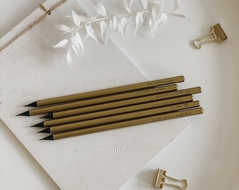 Puede incluir: Un juego de seis lápices dorados con puntas de grafito negro. Cada lápiz tiene una cita inspiradora diferente impresa en letras negras. Las citas son: "Una porción de vida", "Leer es ir", "Hoy es un buen día", "Buenas vibraciones solamente", "Tú eres", "Tú eres simplemente increíble".