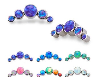 May include: Five opal gemstone body jewellery pieces in a variety of colours, including blue, green, pink, and white. The jewellery is made of surgical steel and is designed to be worn in the body.