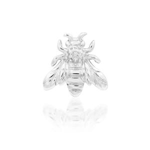 May include: A silver bee charm with a clear rhinestone on its body.