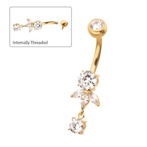 May include: Gold belly button ring with a dangling flower charm. The flower charm has five clear crystal stones and a single clear crystal stone dangles from the centre.