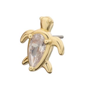 May include: A gold-coloured turtle-shaped earring with a pear-shaped, clear gemstone centre. The turtle has detailed flippers, head, and tail. The earring post is silver-coloured.