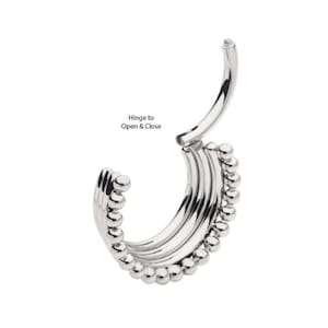 May include: Silver hinged clicker with a beaded design. The hinge is on the top of the clicker and opens and closes to put it in and take it out of the piercing.
