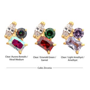 May include: Three gold-toned stud earrings, each featuring a cluster of colorful cubic zirconia stones. The earrings showcase clear, aurora borealis, emerald green, garnet, light amethyst, and amethyst stones. The text on the image reads "Cubic Zirconia."