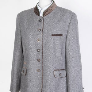 May include: A gray tweed blazer with brown velvet trim and buttons. The blazer has a mandarin collar and two pockets.