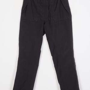 May include: Black pants with a drawstring waist and two pockets on each leg.