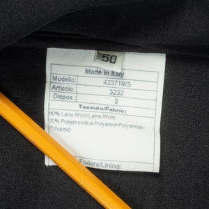 May include: A white tag with black text on a black fabric background. The tag lists the following information: Made in Italy, Modello: 423718/S, Articolo: 3232, Dispos: 0, Teseuto/Fabric: 80% Lana-Wool-Laine-Wolte, 20% Poliam midice-Polyamid-Polyamide-Polyamid, Fodera/Lining: