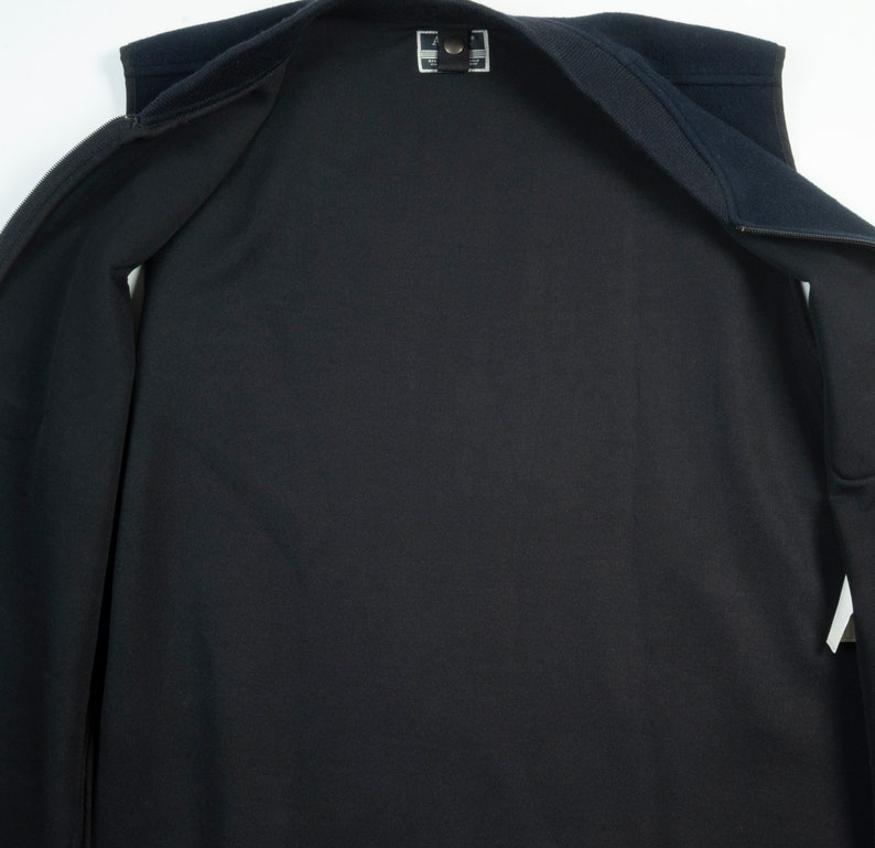 May include: A black fleece vest with a zipper closure. The vest is unzipped and laid flat, showing the inside lining.