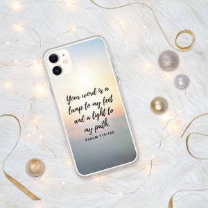 May include: A clear phone case with a sunset background and the text "Your word is a lamp to my feet and a light to my path. PSALM 119:105"