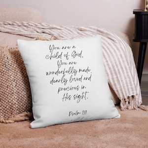 Pode incluir: Travesseiro branco com texto preto que diz "You are a child of God. You are wonderfully made, dearly loved and precious in His sight. Psalm 139"