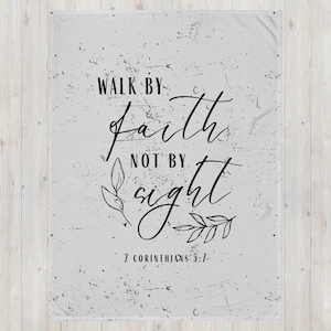May include: A grey and white throw blanket with the text "Walk by faith not by sight" and the scripture reference "2 Corinthians 5:7".