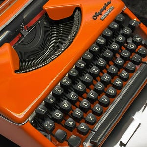 Vintage Orange Olympia Splendid 33 Typewriter with Black Keyboard & Standard Leather Bag - Retro Office Decor