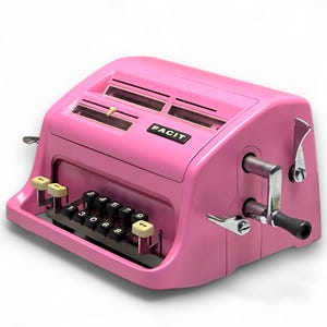 May include: A vintage pink Facit calculator with black number keys and a silver crank. The word "FACIT" is printed on the front. The calculator has a retro design with a combination of black, silver, and pink.
