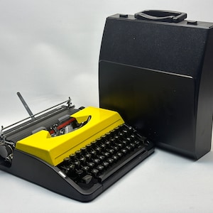 Adler Triumph Schreibmaschine mit QWERTZ-Tastatur, Gelber Abdeckung, Schwarzen Tasten - Antike Schönheit, voll funktionsfähige manuelle Schreibmaschine