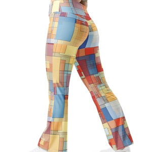 Puede incluir: Un par de leggings acampanados con un patrón geométrico en tonos de amarillo, azul, rojo y marrón.