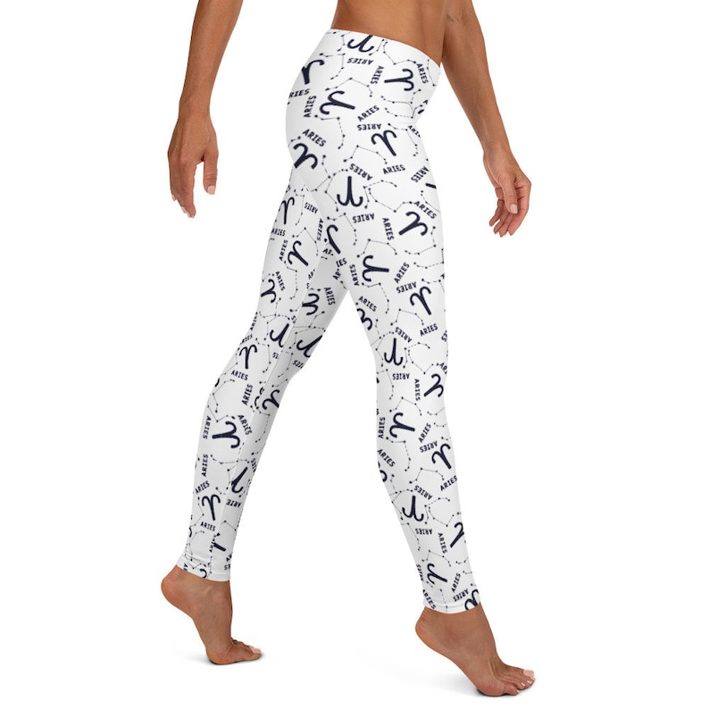 Puede incluir: Leggins blancos con un patr&oacute;n repetido del signo zodiacal Aries en azul marino. El signo est&aacute; rodeado de una constelaci&oacute;n de estrellas.