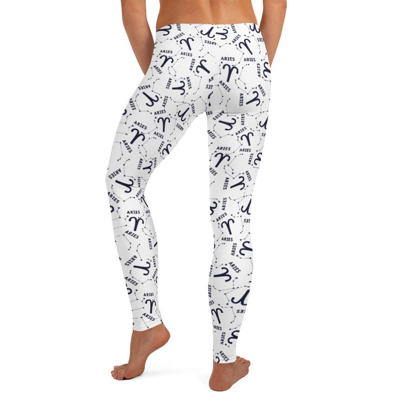 Puede incluir: Leggings blancos con un patr&oacute;n repetido del signo del zod&iacute;aco Aries, la constelaci&oacute;n y la palabra "Aries" en azul marino.