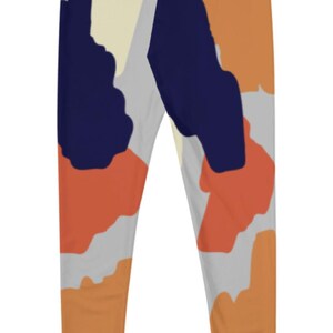 May include: A pair of leggings with an abstract print featuring shades of orange, blue, yellow, and gray.