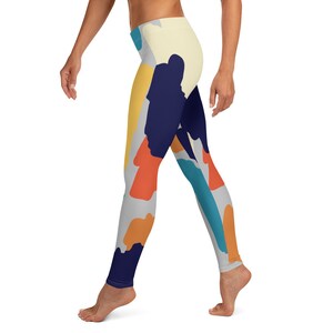 May include: A pair of leggings with a colorful abstract print featuring shades of blue, orange, yellow, and gray.
