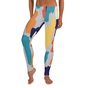 May include: A pair of leggings with a colorful abstract print featuring shades of blue, orange, yellow, and red on a light gray background.