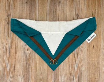 May include: Teal and brown fabric collar with a gold ring detail. The collar has a white lining and the text "Barkin" is printed on a white tag.