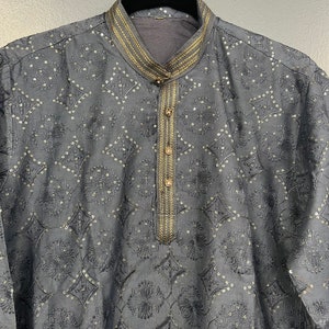 May include: A grey kurta with a gold embroidered pattern and trim. The kurta has a mandarin collar and a button closure.