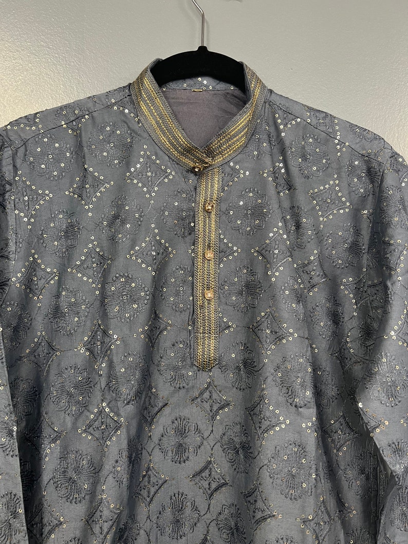 May include: A grey kurta with a gold embroidered pattern and trim. The kurta has a mandarin collar and a button closure.