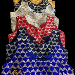 May include: A stack of six sequined crop tops in various colors, including gold, black, white, red, navy blue, and royal blue. The tops have a geometric pattern of gold sequins on a velvet fabric. The tops are arranged in a stack, with the gold top on the bottom and the royal blue top on the top.