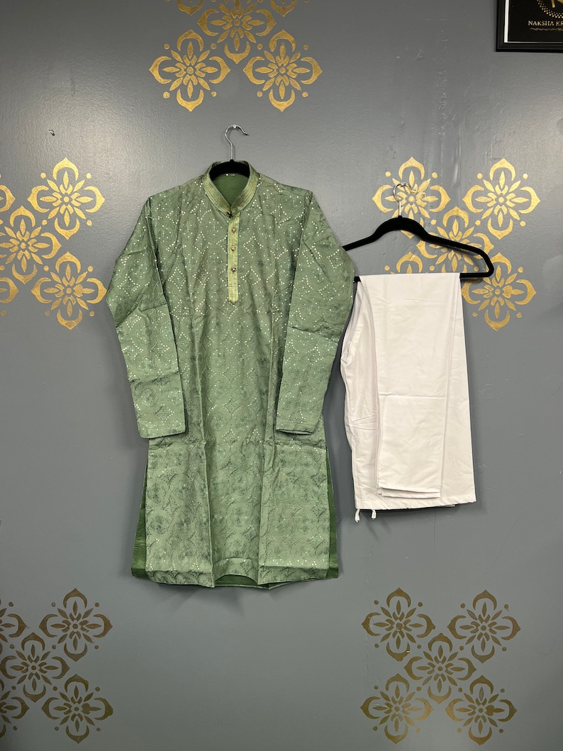 May include: A green kurta with white embroidery and a white pair of trousers. The kurta has a button-up collar and long sleeves.