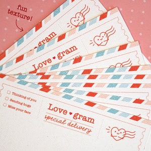 May include: A stack of colorful love gram cards with a red heart and the text "Love gram special delivery" on the front. The cards have a fun, textured design.