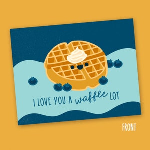 May include: A greeting card with a cartoon waffle with a smiling face and a dollop of whipped cream on top. The waffle is surrounded by blueberries and the text "I love you a waffle lot" is written in blue on a blue and white background.
