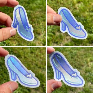 May include: Four glass slipper stickers with a blue iridescent finish. The stickers are shaped like a glass slipper and have a silver glitter design.