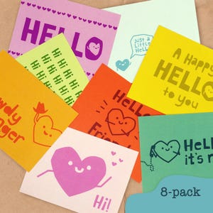 May include: A collection of colorful cards with the word "HELLO" and heart illustrations. The cards are in various colors, including pink, yellow, orange, and green. Some cards have additional text like "Hi!" and "A Happy HELLO to you".