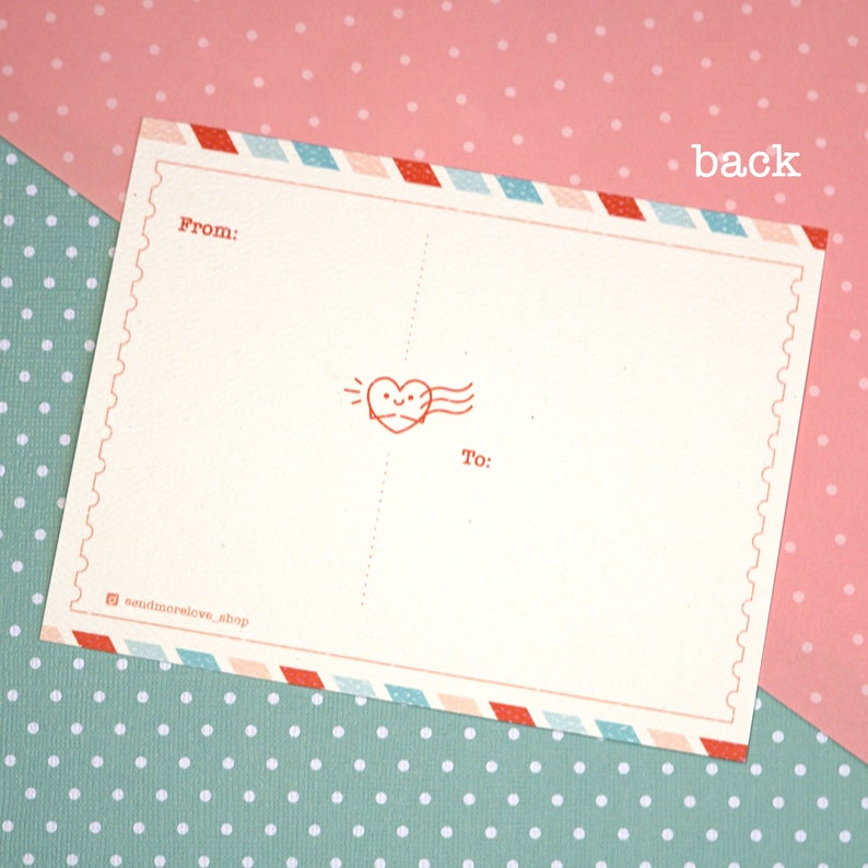 May include: A blank postcard with a red heart design and the words "From:" and "To:" printed on it. The postcard has a blue, white, and red border.