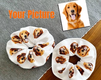 May include: Two white scrunchies with a repeating pattern of a golden retriever dog's face.