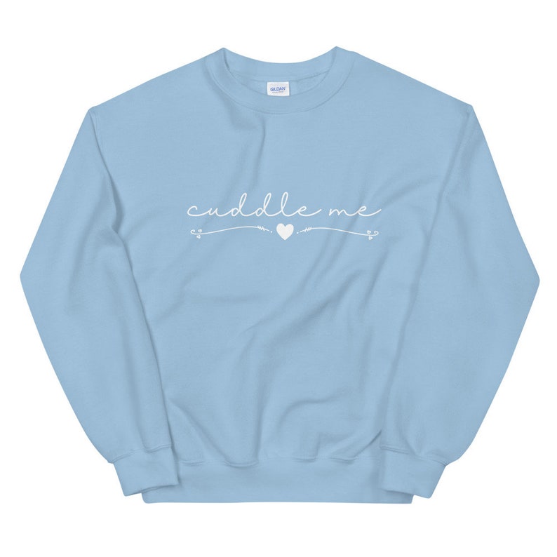May include: Light blue sweatshirt with the text "cuddle me" in white cursive lettering with a small white heart in the middle.