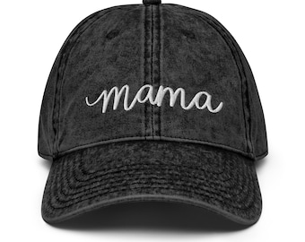 May include: Black distressed denim baseball cap with white embroidered text that reads "mama".