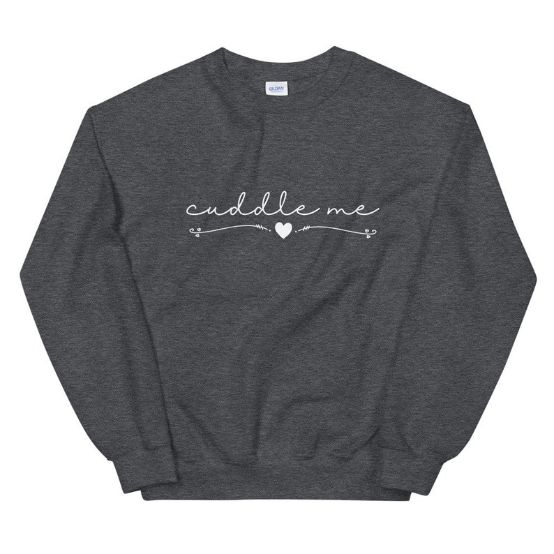 May include: A dark gray sweatshirt with the text "cuddle me" in white cursive lettering with a small heart symbol.