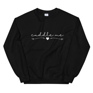 May include: Black sweatshirt with white text that says "cuddle me" with a small heart in the middle.