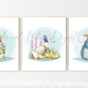 Peut inclure: Un ensemble de trois impressions aquarelle représentant des personnages de Peter Rabbit. La première impression montre Peter Rabbit en train de manger une carotte. La deuxième impression montre un canard avec ses canetons. La troisième impression montre la mère de Peter Rabbit en train d'embrasser Peter Rabbit.