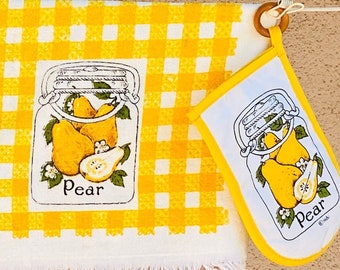 Pode incluir: Conjunto de três toalhas de cozinha amarelas e brancas com padrão xadrez e uma ilustração de pêra em um frasco. As toalhas incluem um pegador de panela, uma toalha de chá e uma toalha de mão. O texto "Pera" está impresso em cada toalha.