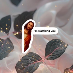 Może przedstawiać: Naklejka z obrazem Jezusa z tekstem "Patrzę na ciebie". Naklejka jest umieszczona na różowym i zielonym tle z złotym brokatem.