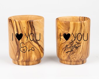 May include: Two wooden cups with the words "I love you" and a heart design. One cup has a key and lock design, the other has two hands holding a heart.