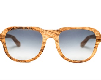 May include: A pair of wood-framed sunglasses with a gradient blue lens. The frame is made of natural wood with a unique grain pattern.