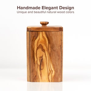 May include: A wooden box with a lid, made of olive wood with a natural wood grain pattern. The box has a rectangular shape and a smooth finish.