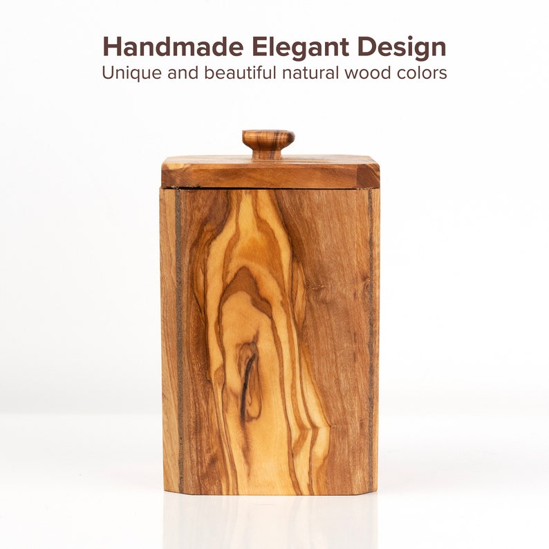 May include: A wooden box with a lid, made of olive wood with a natural wood grain pattern. The box has a rectangular shape and a smooth finish.