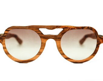 May include: A pair of round, brown wood-framed sunglasses with gradient lenses. The sunglasses have a unique, intricate wood grain pattern.